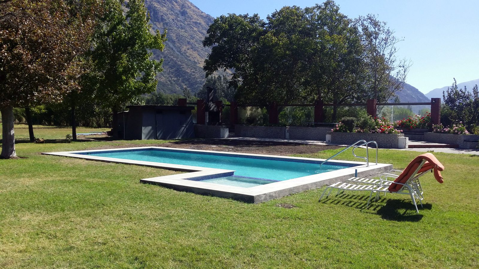 Piscina en L en jardín de campo